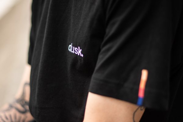 Close up look at the dusk logo embroided on a t-shirt