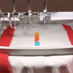 dusk logo being embroided on a tshirt